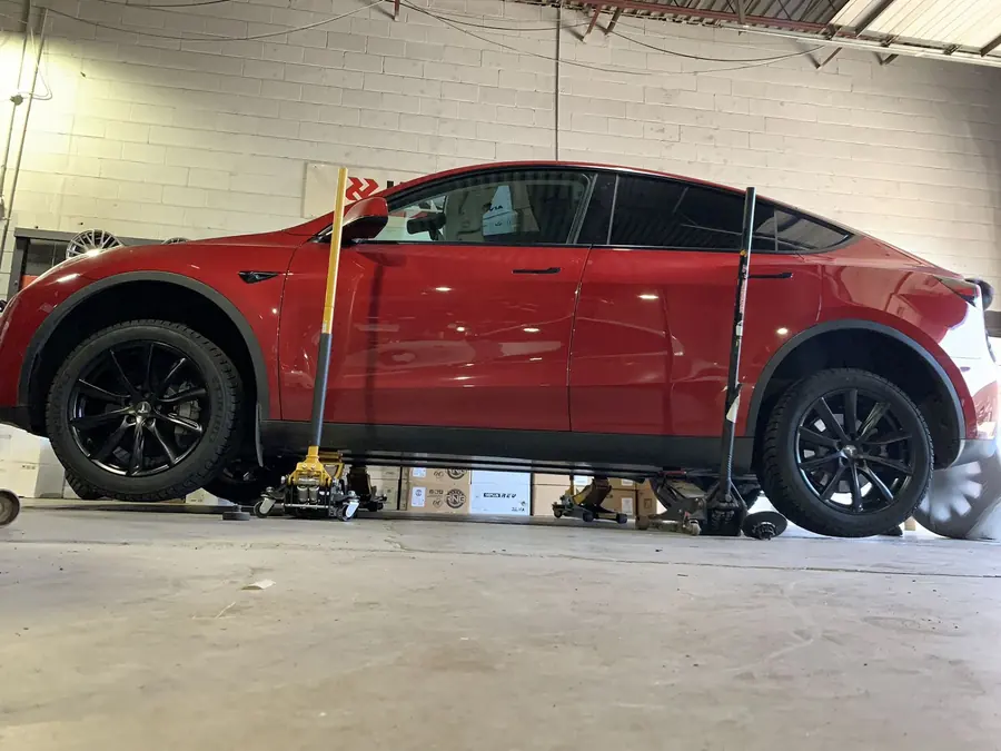 Tesla Model Y raised on jack stands for a winter tire changeover