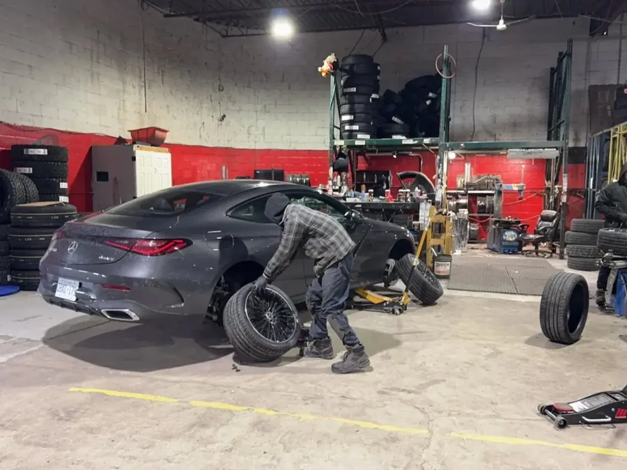 Technician mounting a winter tire on a Mercedes coupe at Taylor Tire